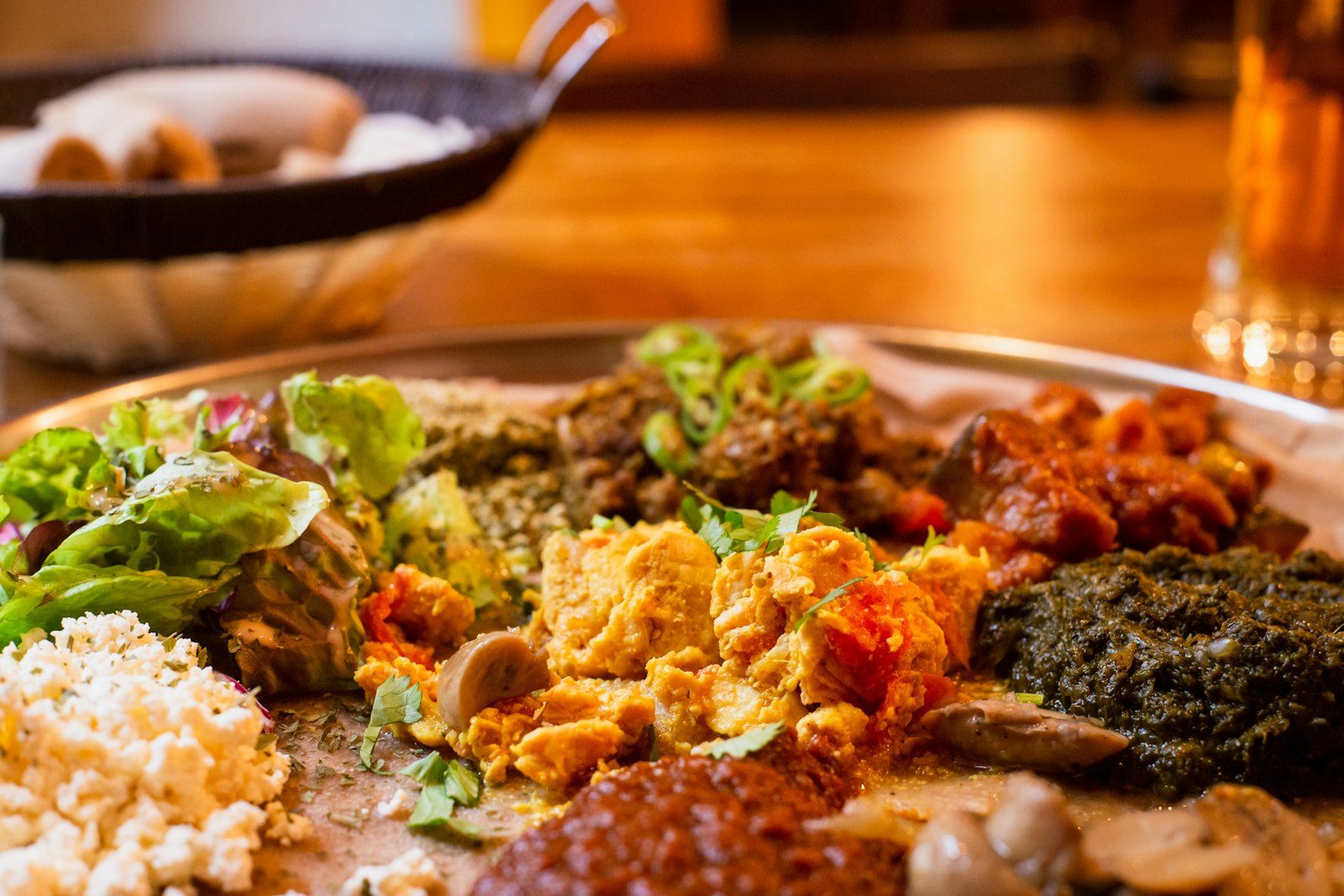 A fresh green condiment beside a rich cooked dish