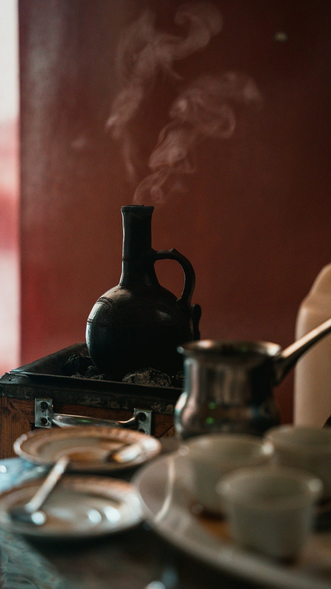 A jebena, the traditional Ethiopian and Eritrean coffee pot, boiling over coals — photo by Yosef Futsum