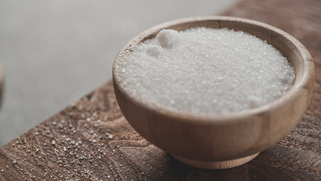 Coarse salt in a wooden bowl on a wooden table — placeholder editorial photo, replace with brand shot